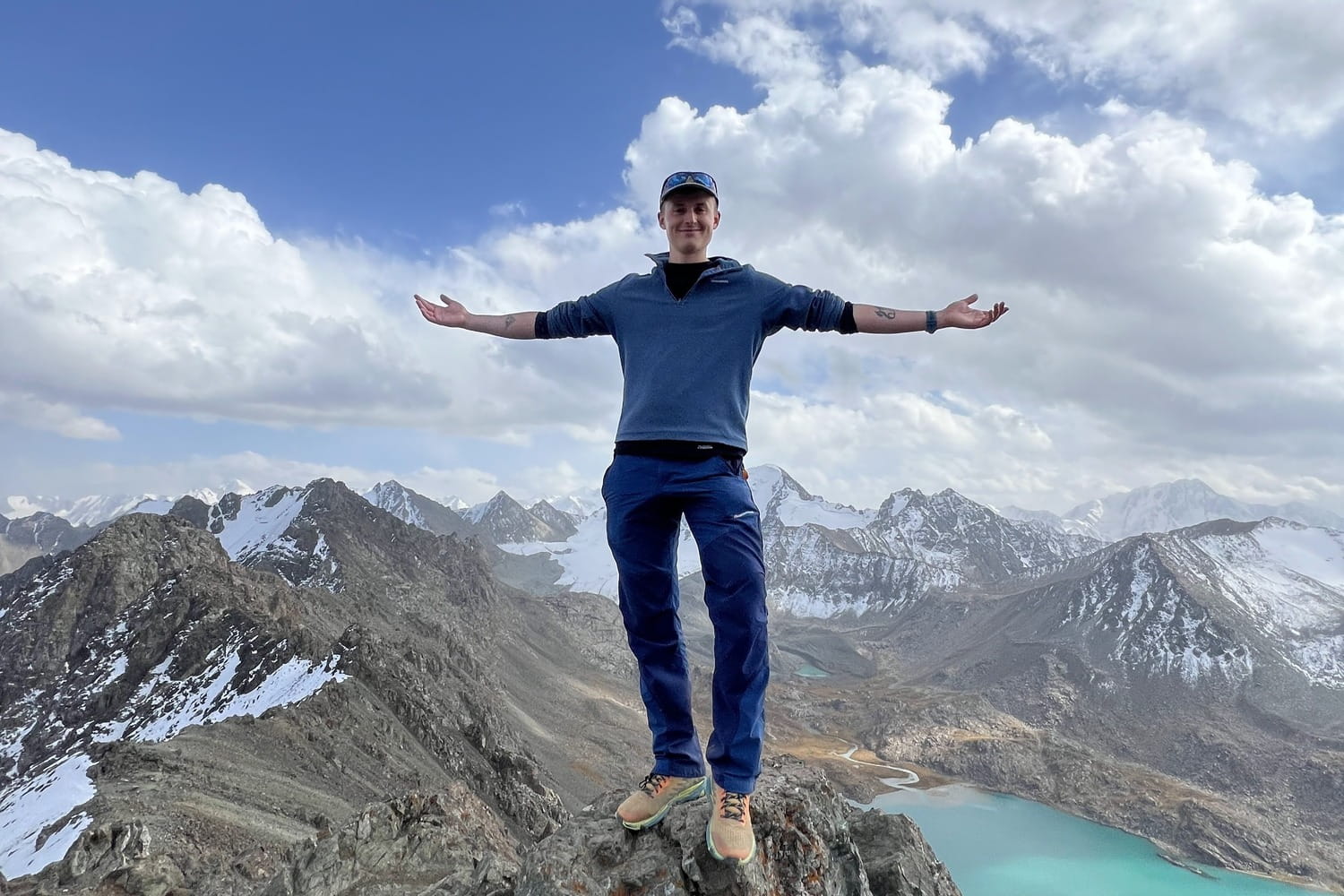 Hiker posing atop Ala-Kul Pass.