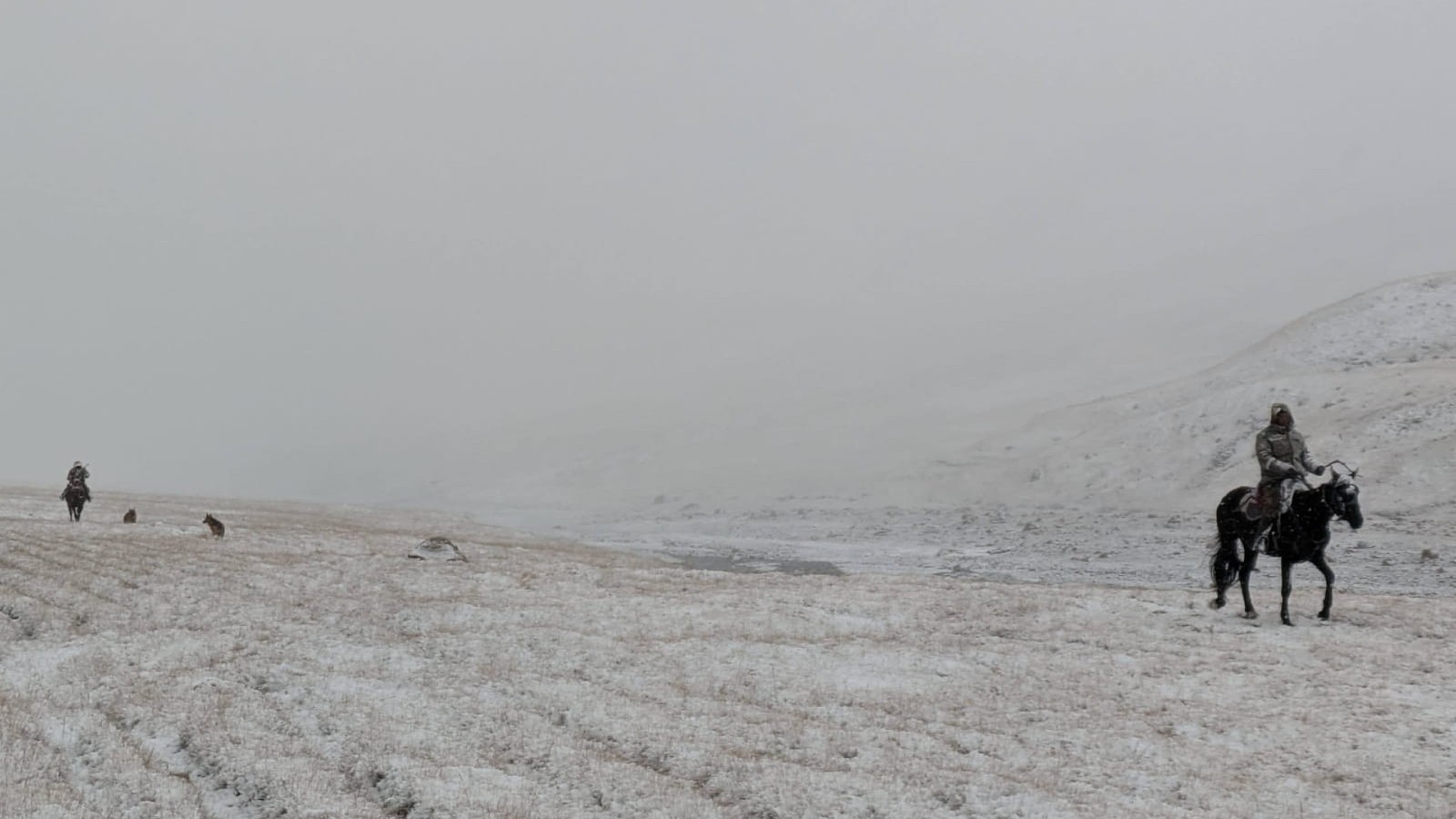 Nomads on horses in a whiteout
