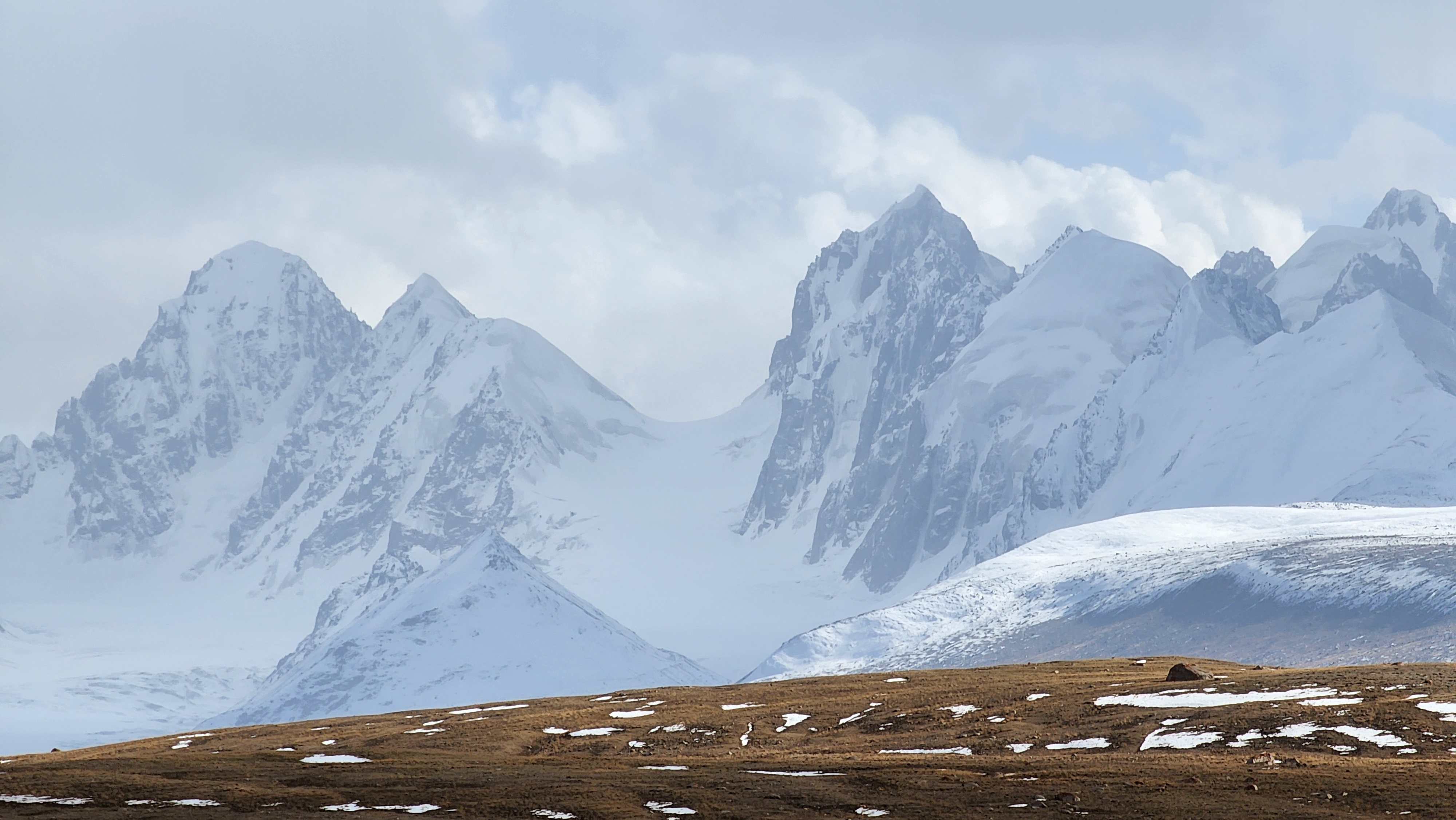 Snowy capped mountains behind the clouds